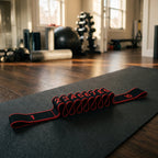 Black and red 10-loop stretch strap on a gym mat