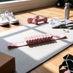 Pink stretch strap on a yoga mat with dumbbells