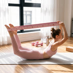 Boat pose stretch holding a pink numbered strap